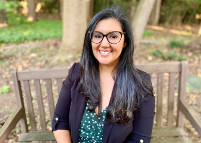 Young woman with glasses sitting on a bench